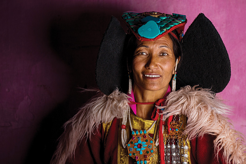 امرأة من السكان المحليين ترتدي البيراك، وشاح رأس تقليدي مرصع بالفيروز والمرجان وترتديه البوذيات المتزوجات في المنطقة.