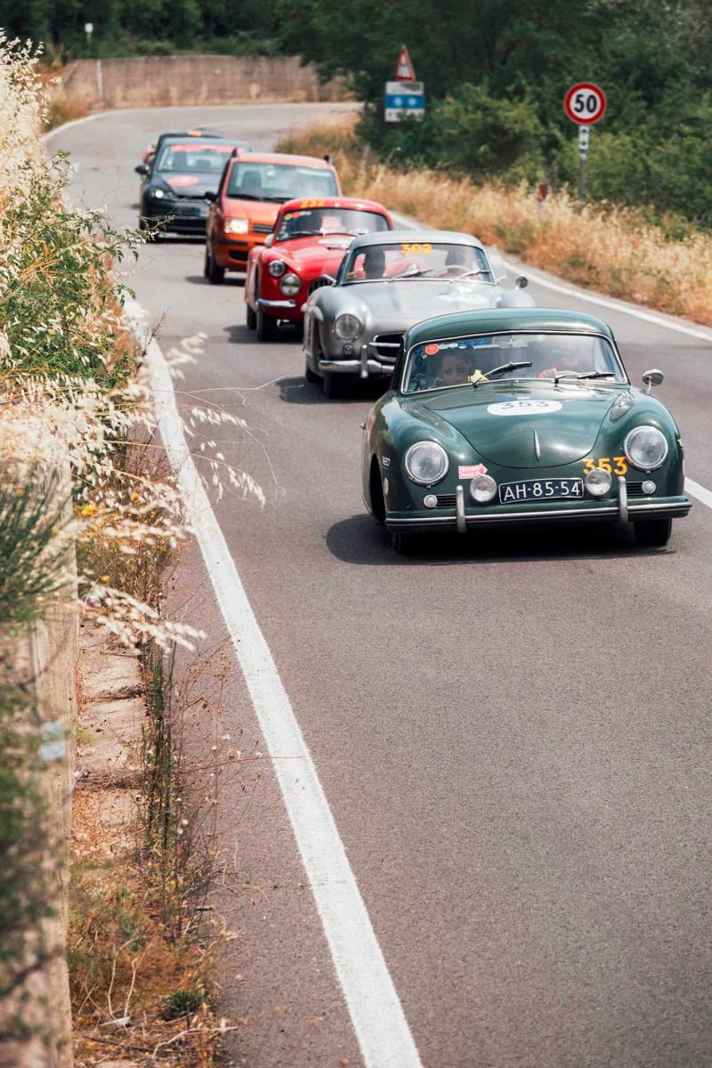 على الطريق من روما إلى بارما في اليوم الثالث والأصعب من السباق، وتظهر في المقدمة سيارة من طراز Porsche 356 1500 من عام 1953.