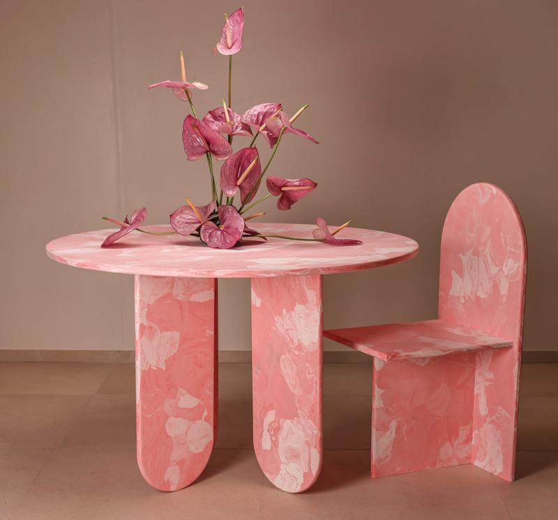 كرسي وطاولة Moonrise من علامة Anqa Studios، مصنوعان من البلاستيك المعاد تدويره بتدرجات لونية وردية.