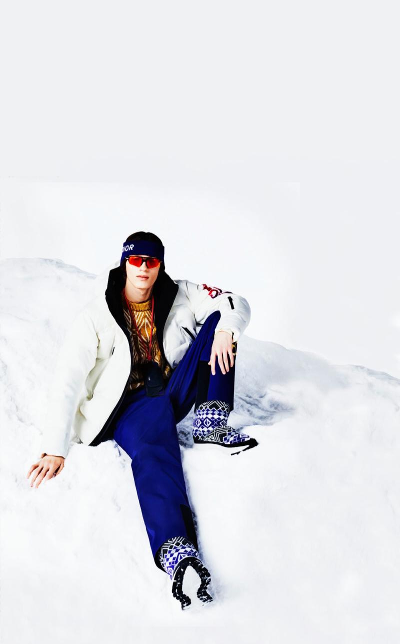 إطلالة من مجموعة Dior Ski Capsule تزاوج بين سترة وسروال من القماش المعالج تقنيًا، وكنزة محبوكة من الصوف. 