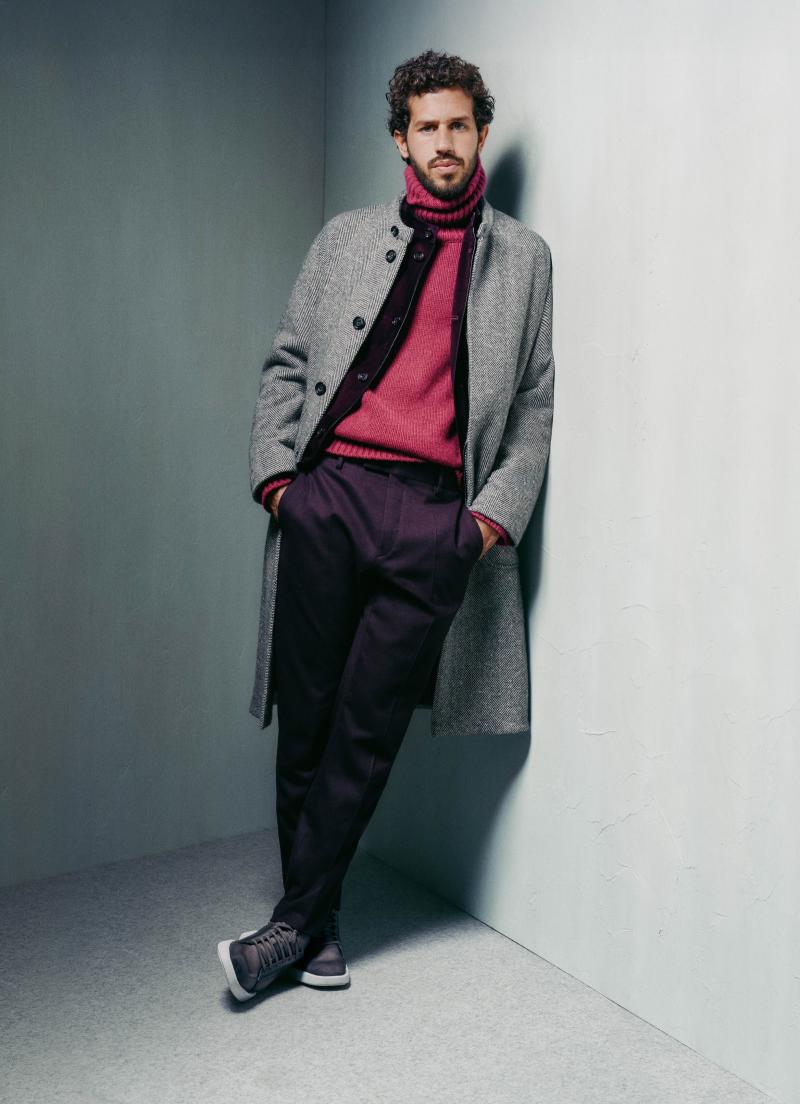 معطف Herringbone Forestière، حيك من الكشمير، وسترة Light Cashmere Forestière المشغولة من الكشمير، وكنزة بياقة مرتفعة محبوكة من الكشمير، وسروال Alessandro المشغول من مزيج الصوف والإيلاستان، والحذاء الرياضيStellar Scritto   المصنوع من جلد فينيتزيا. / مجموعة أزياء موسم خريف 2025 وشتائه من بيرلوتي 