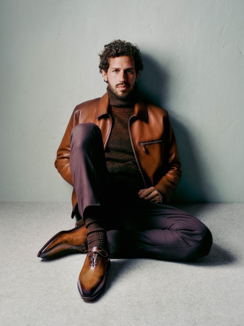 سترة Patina 1 Jour Blouson، مشغولة من جلد العجول، وكنزة بياقة مرتفعة محبوكة من الكشمير الخالص، وسروال Alessandro مشغول من الصوف والإيلاستان، وحذاء أكسفورد من طراز Alessandro Démesure مصنوع من جلد فينيتزيا. / مجموعة أزياء موسم خريف 2025 وشتائه من بيرلوتي 
