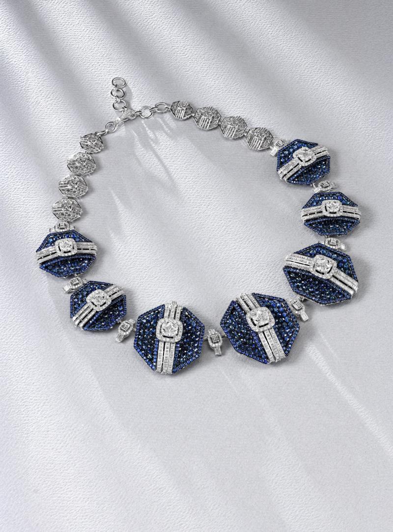 عقد Blue Sapphire، صيغ من الذهب عيار 18 قيراطًا ورُصّع بالألماس بقطع الوردة والقطع البرّاق، وبأحجار من الياقوت الأزرق تزن أكثر من 50 قيراطًا. 