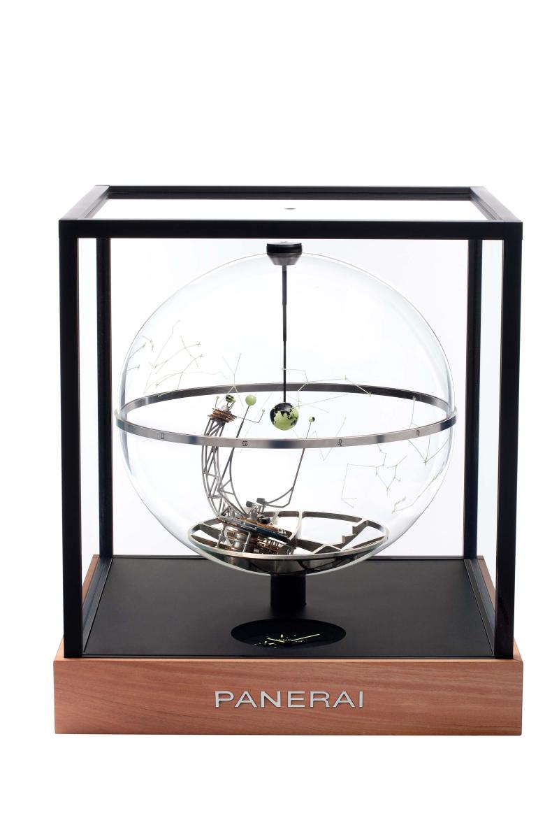 عبر الكرة الزجاجية للساعة، يطلّ مجسم الأرض من المركز وحوله الشمس والقمر والمشتري وأقماره الأربعة.