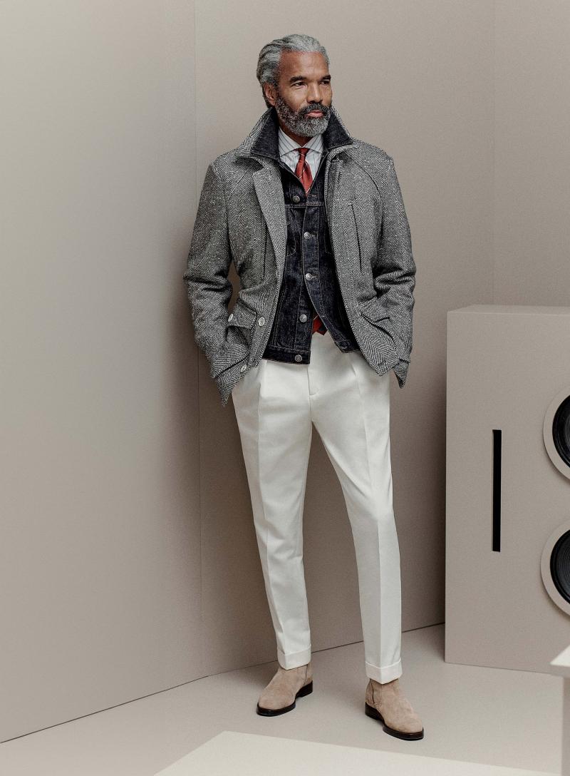 سترة من الكشمير تزهو بنقوش هرينغبون المتعرجة، وسترة من الدنيم، وقميص مشغول من القطن، وسروال من القطن والكتان، وربطة عنق مشغولة من الحرير، وحذاء تشيلسي مصنوع من الجلد المقلوب. 