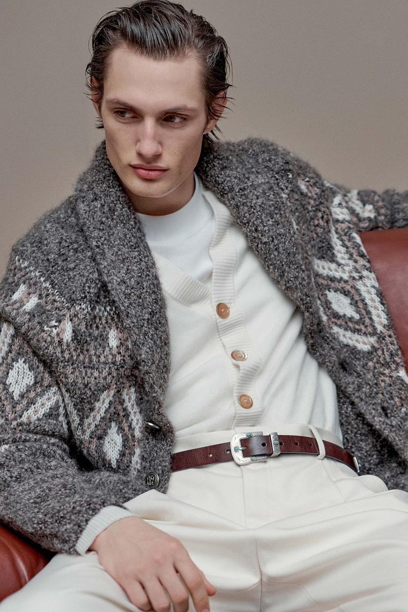 كنزة مفتوحة بأزرار معدنية، محبوكة من مزيج صوف الألبكة والصوف البكر والكشمير ومزدانة بنقوش الجاكارد، وكنزة مفتوحة مشغولة من الكشمير، وقميص تي – شيرت من القطن، وسروال من القطن والصوف البكر، وحزام من جلد العجول. 