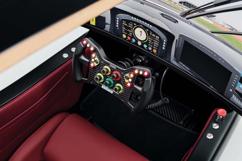 لتعزيز الطابع الواقعي للتجربة، جُهّزت عجلة القيادة القابلة للتخصيص بأذرع لتبديل السرعة مصنوعة من ألياف الكربون، وبمجموعة من الأقراص الدوّارة والأزرار الضاغطة