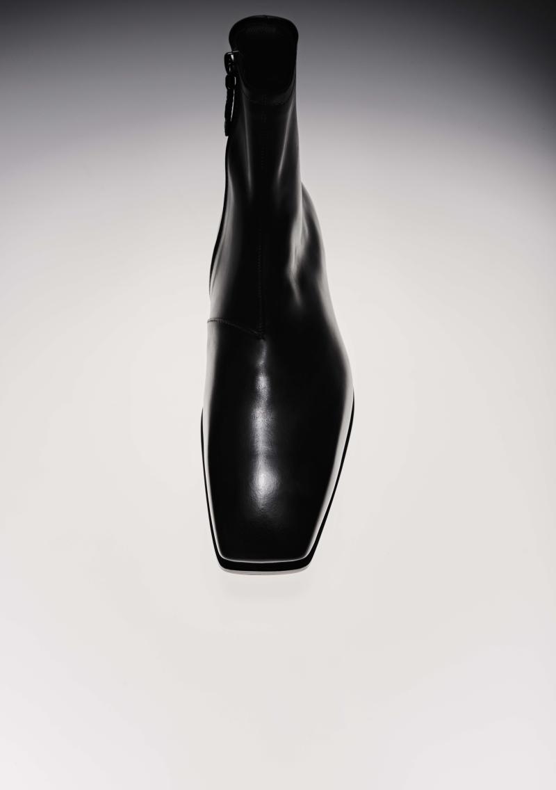 حذاء يرتفع إلى ما فوق الكاحل من بيرلوتي، مشغول من جلد العجول باللون الأسود (2,600 دولار). 