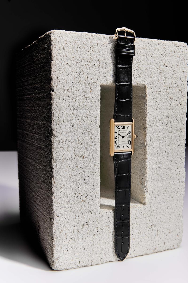 ساعة Tank Louis Cartier من كارتييه، تستوطن علبة بحجم 33.7 ملليمتر x 25.5 ملليمتر، مشغولة من الذهب الوردي عيار 18 قيراطًا (13,500 دولار). 