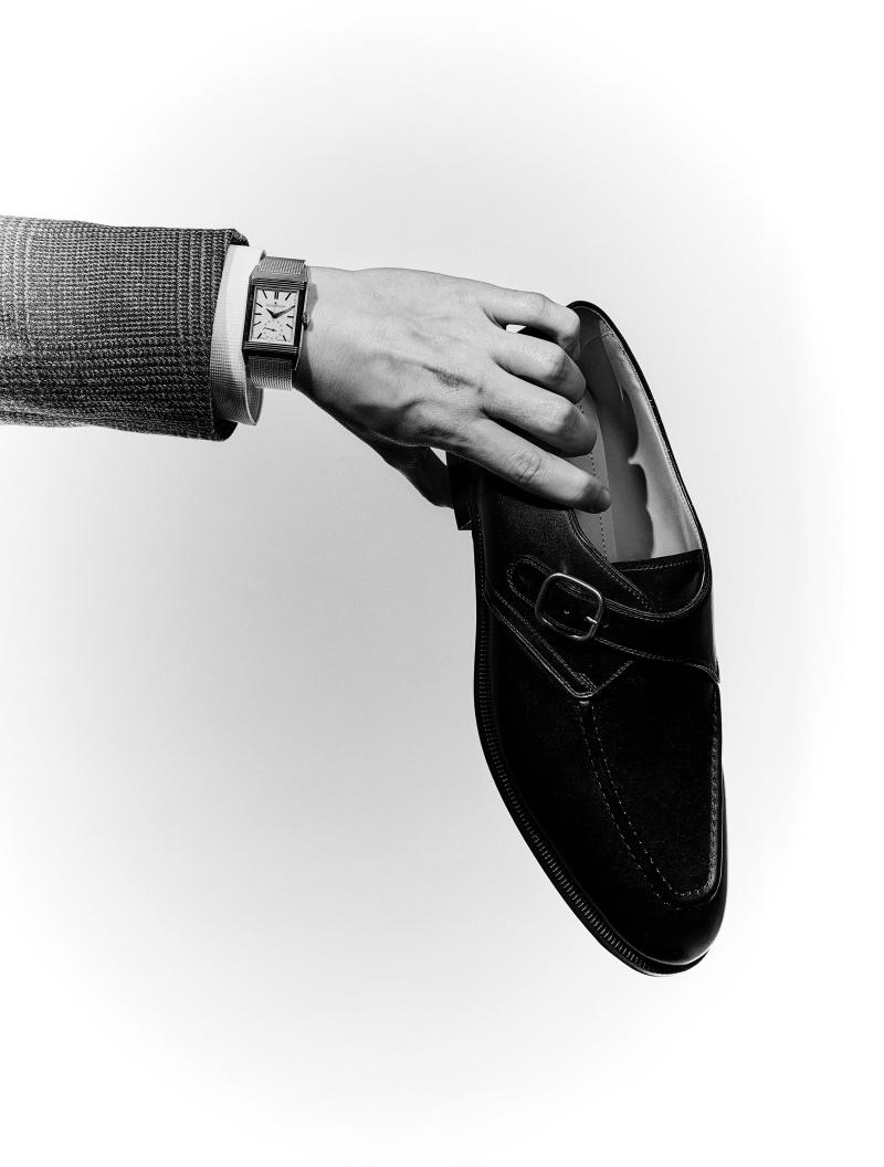 ساعة Reverso Tribute Monoface Small Seconds من جاجيه – لوكوتر، صيغت في علبة من الذهب الوردي عيار 18 قيراطًا بحجم 45.6 ملليمتر x 27.4 ملليمتر (41,300 دولار)، وسترة من الصوف باللون الرمادي من درايز فان نوتن (1,365 دولارًا)، وقميص أبيض من الساتان من هيرميس (1,425 دولارًا)، وحذاء أسود من لورو بيانا، مشغول من جلد العجول (1,280 دولارًا). 