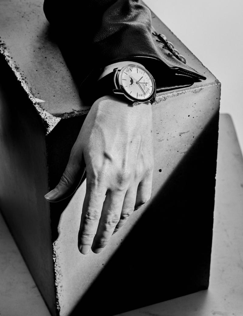 ساعة Patromony Moon Phase Retrograde Date من فاشرون كونستانتين، تستوطن علبة بقطر 42.5 ملليمتر مشغولة من الذهب الأبيض عيار 18 قيراطًا (55,000 دولار، يقتصر إنتاجها على 270 نموذجًا)، وسترة من لويس فويتون، حيكت من الجلد باللون الأسود (5,900 دولار).  