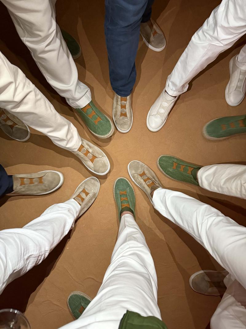 مجموعة من أعضاء النادي يستعرضون التصميمين الخاصين من حذاء Triple Stitch اللذين انبثقا عن التعاون مع دار زينيا.